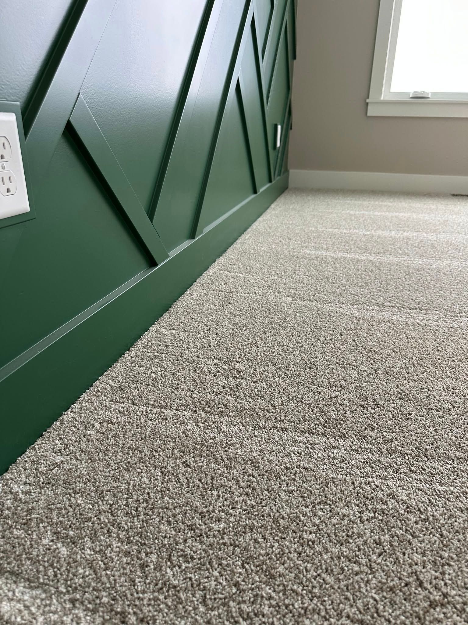 A room with a green wall and a carpeted floor.