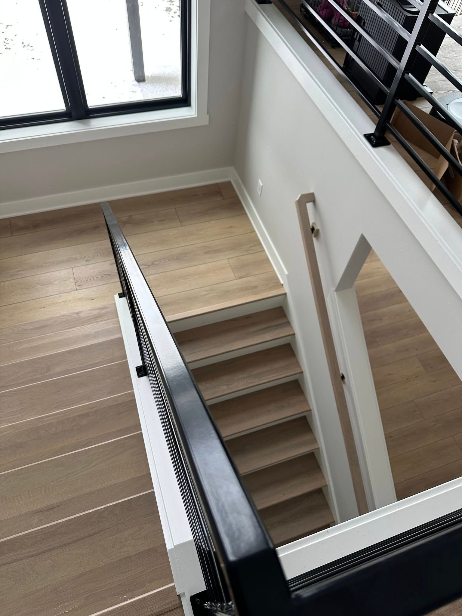 A view of a staircase from the second floor of a house.