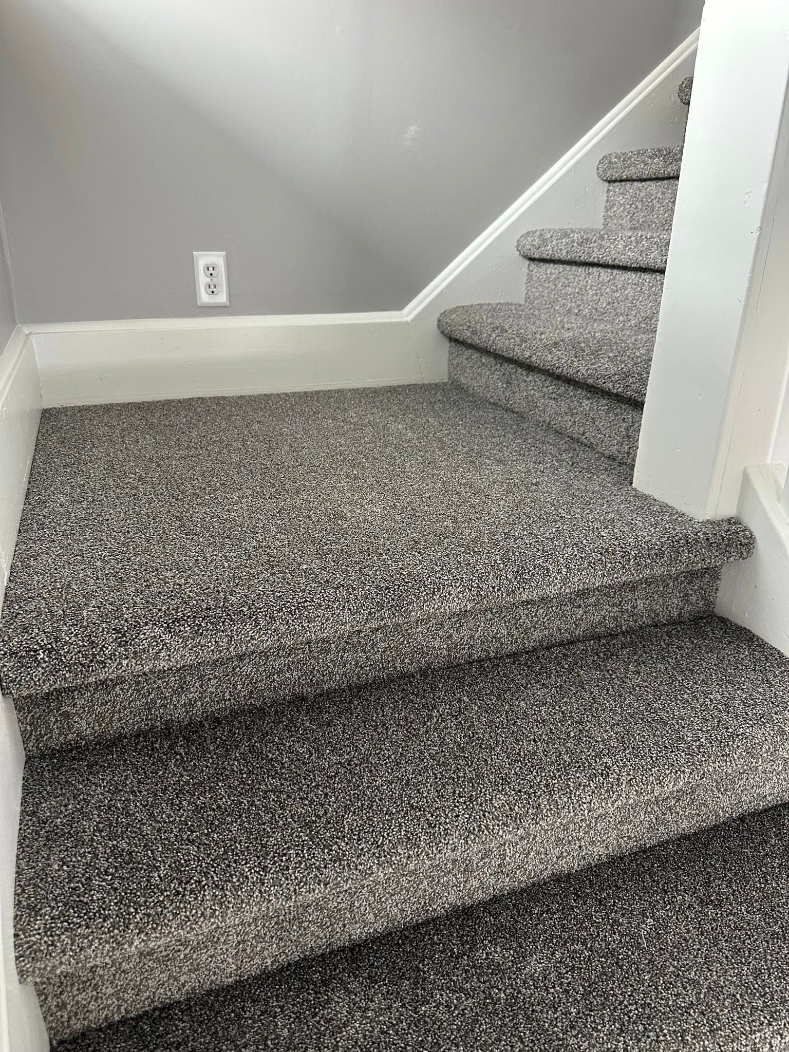 A set of stairs with a gray carpet on them.