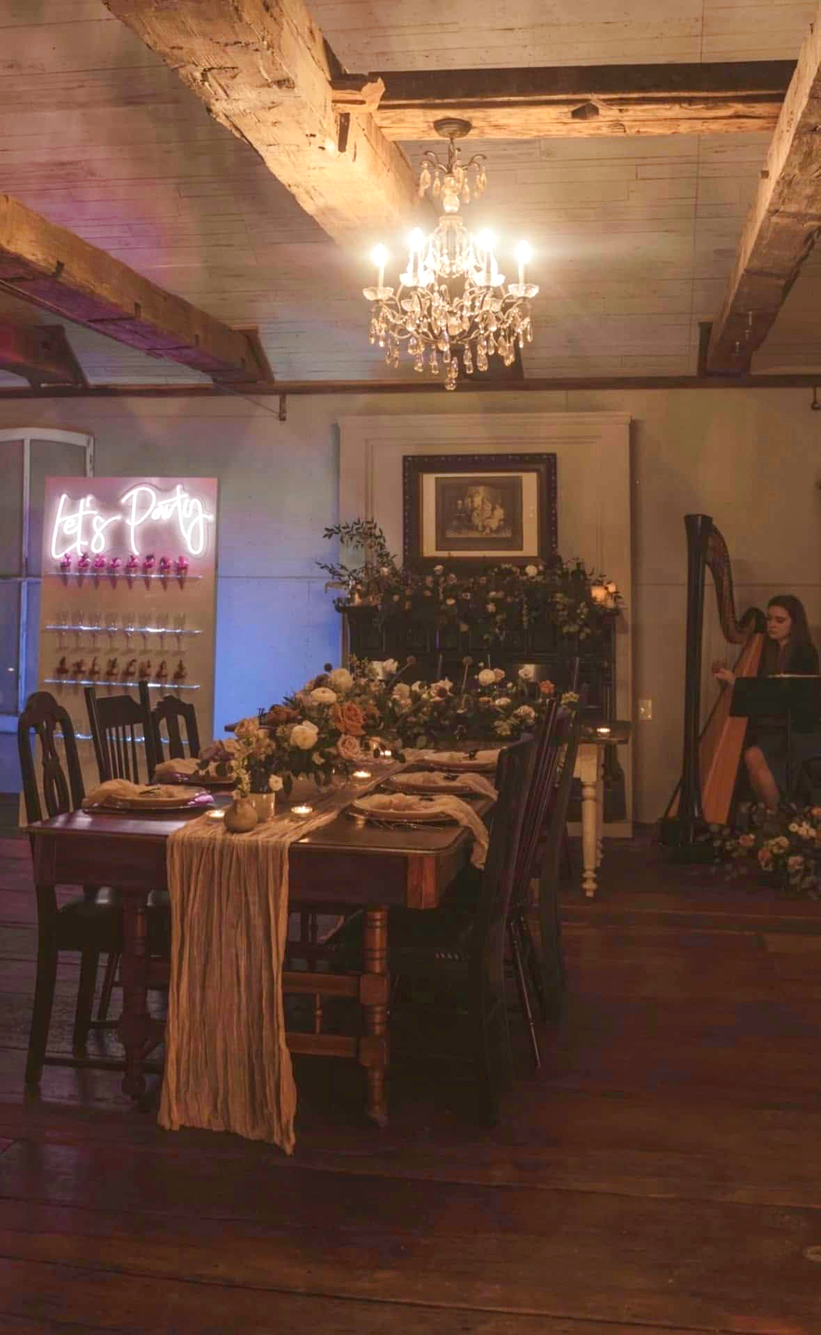 Elegant dining room with chandelier, long decorated table, and warm ambient lighting