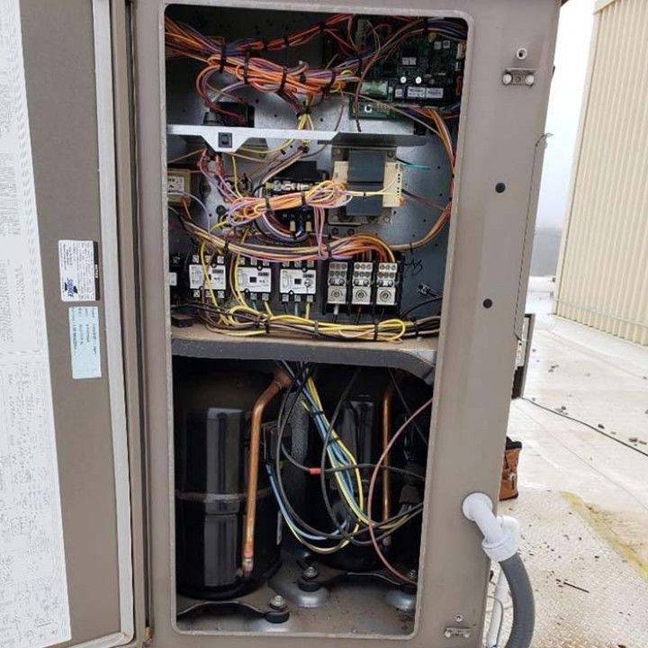 The inside of an air conditioner with a lot of wires coming out of it.