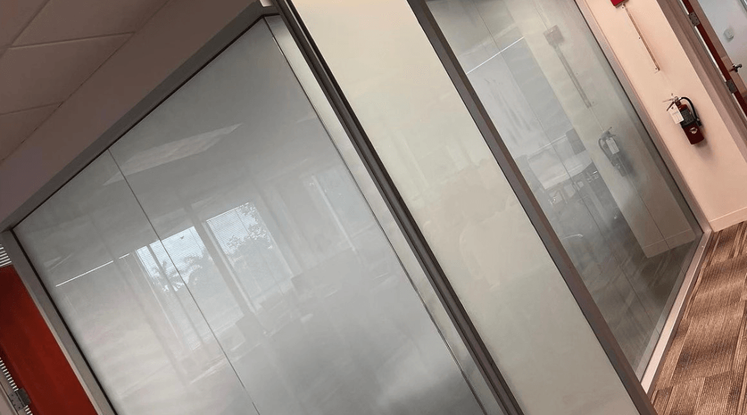 Windows of a building, with a white frame and a view of an interior.