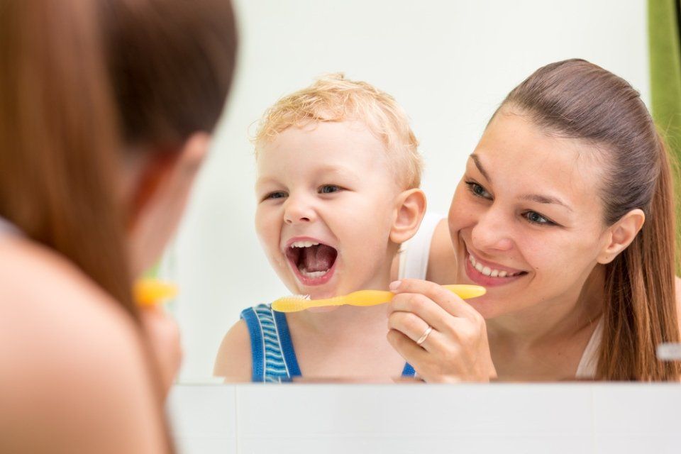 un bambino che si lava i denti con la mamma