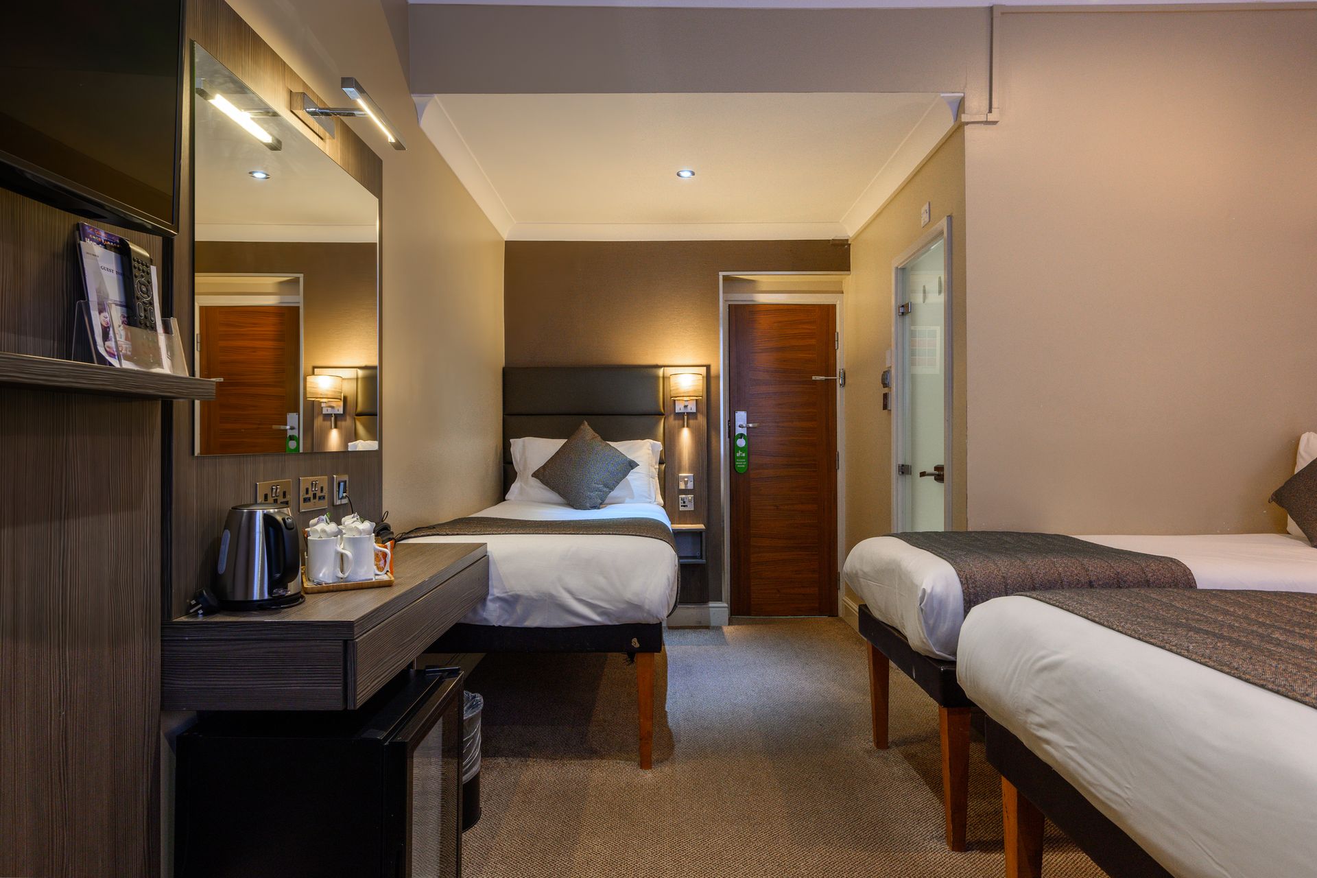 una habitación de hotel con dos camas y una cómoda.