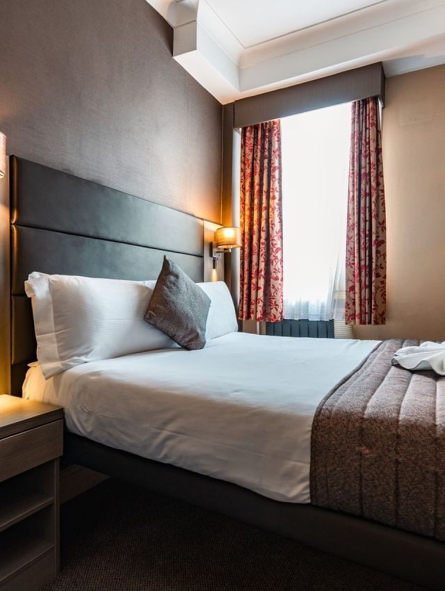 una habitación de hotel con una cama king size y una ventana