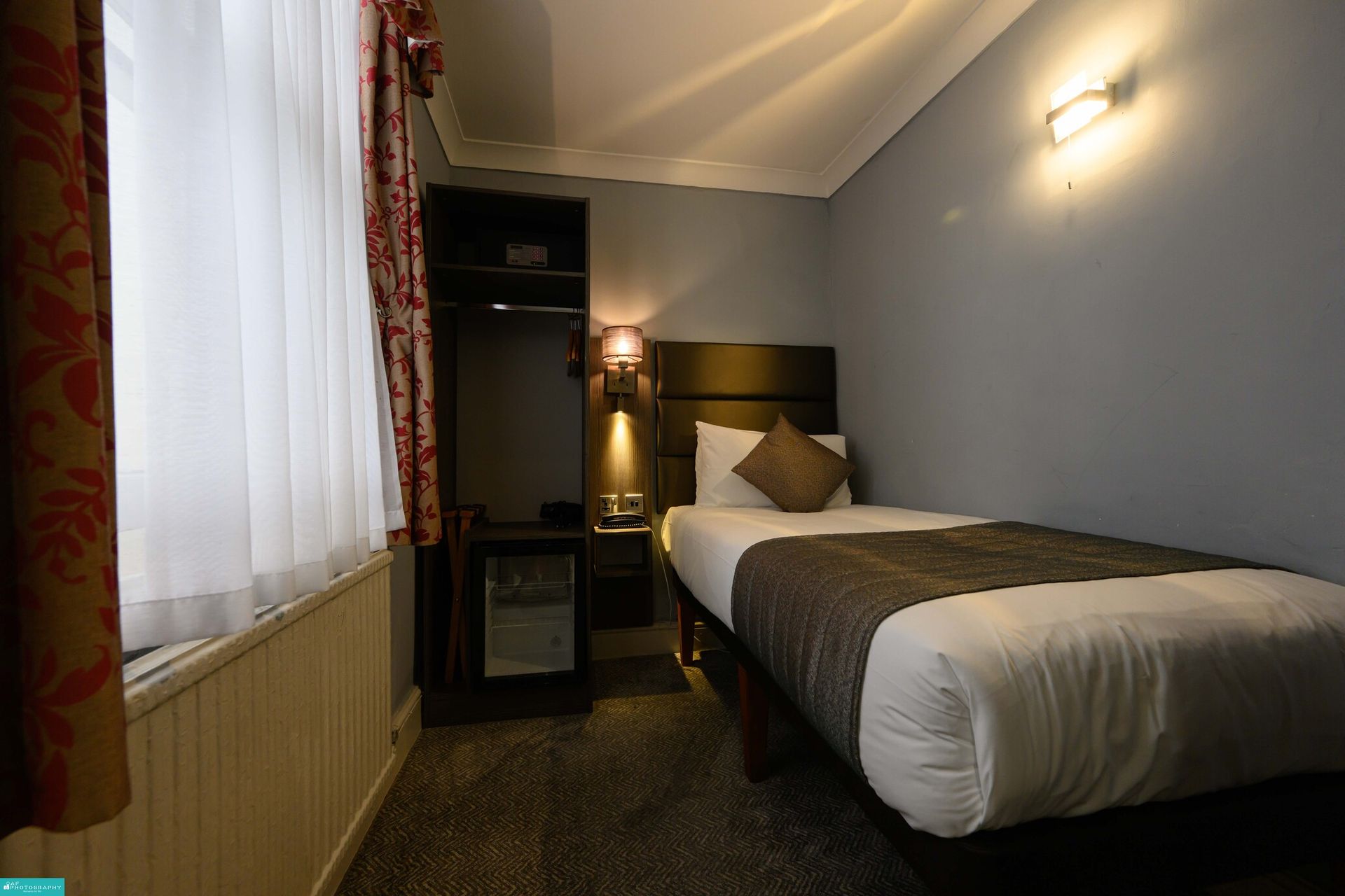 una camera d'albergo con un letto singolo e una finestra