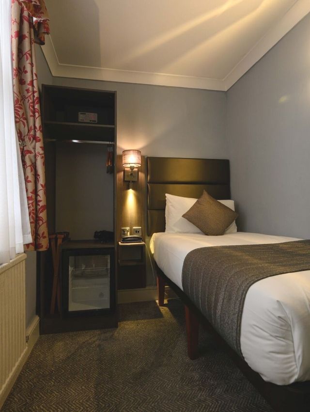 una habitación de hotel con una cama individual y una ventana