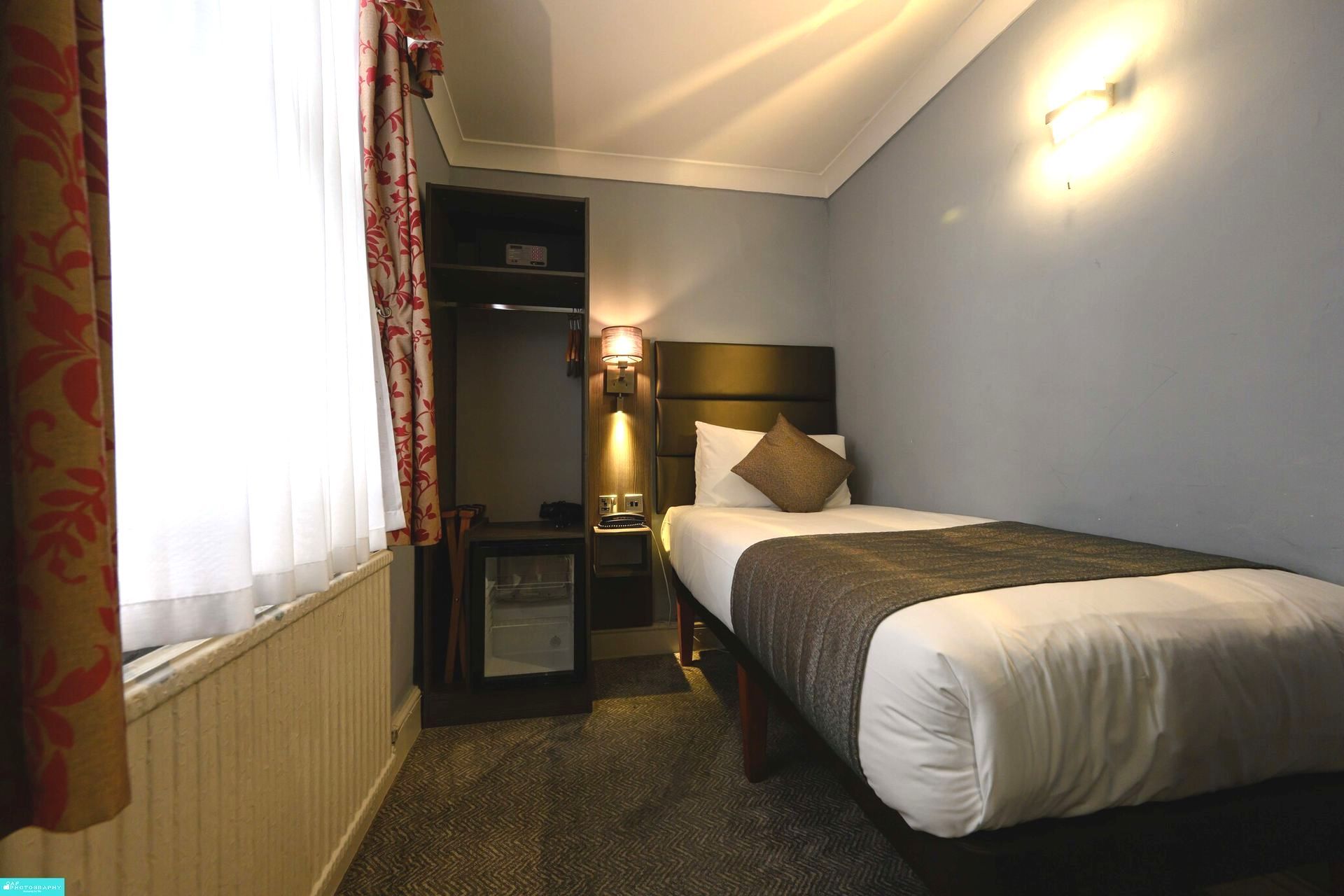 una camera d'albergo con un letto singolo e una finestra