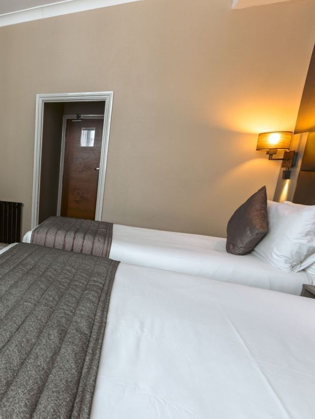 una habitación de hotel con dos camas y una puerta