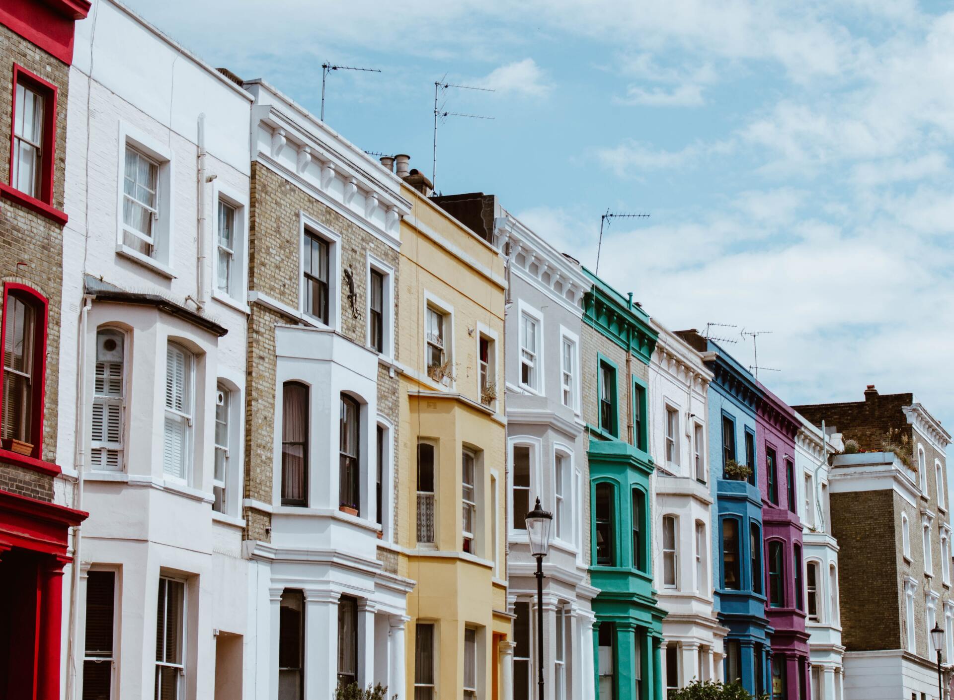 Una hilera de casas coloridas en una calle con un cielo azul de fondo.