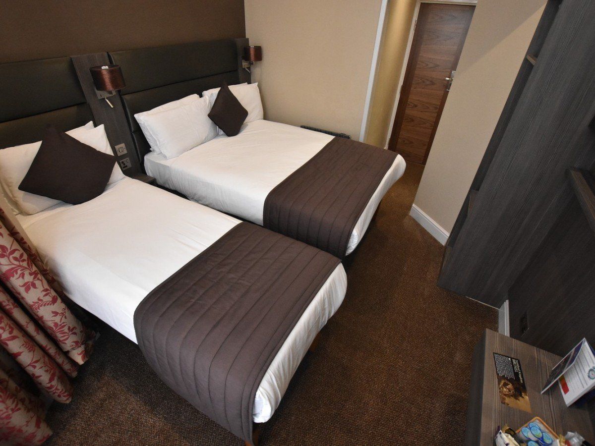 una camera d'albergo con due letti e un televisore