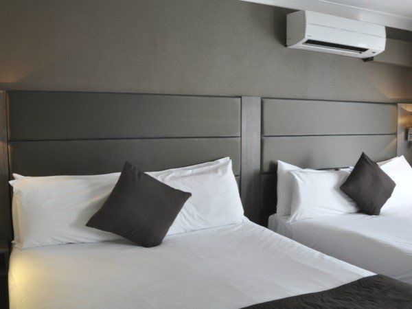 una habitación de hotel con dos camas y aire acondicionado