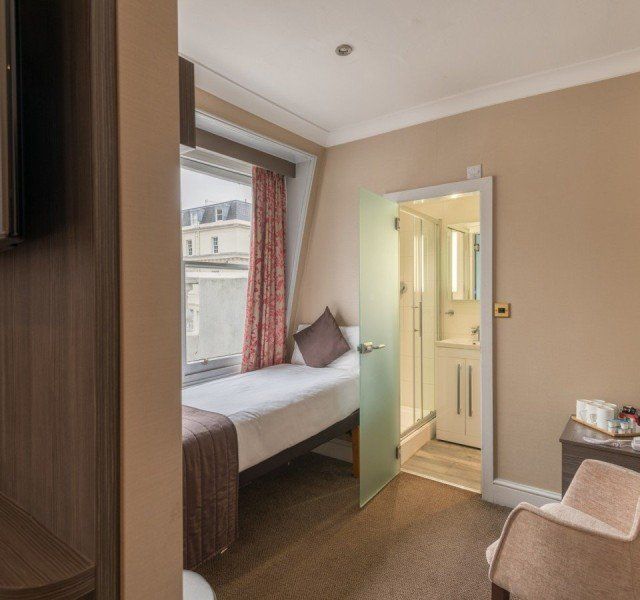 una habitación de hotel con una cama individual y una silla