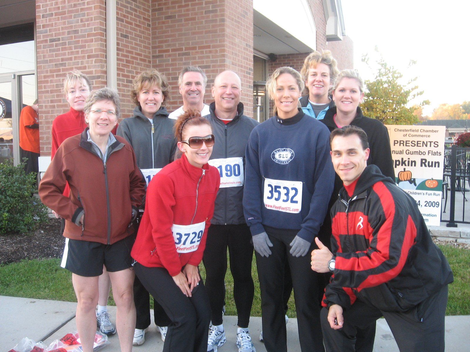 A group of people posing for a picture with one wearing the number 3532
