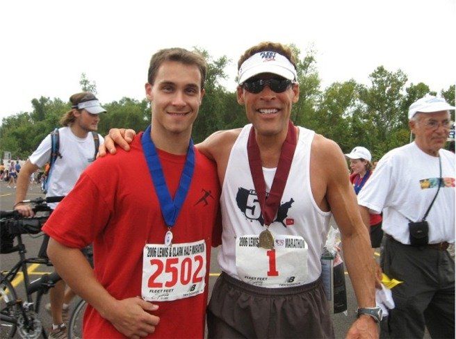 Two men are posing for a picture and one has the number 2502 on his shirt