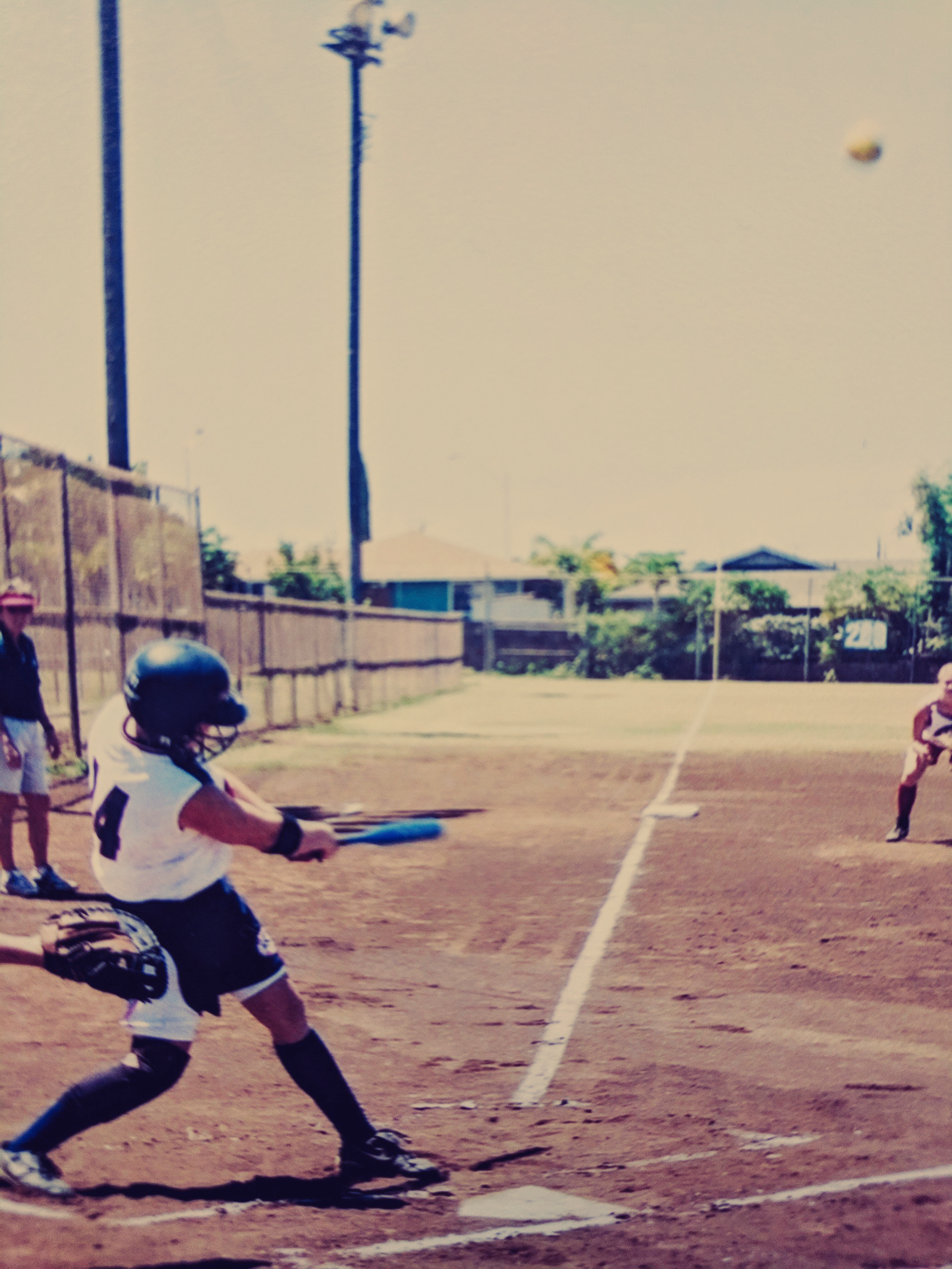 A person with the number 4 on their jersey is swinging a bat