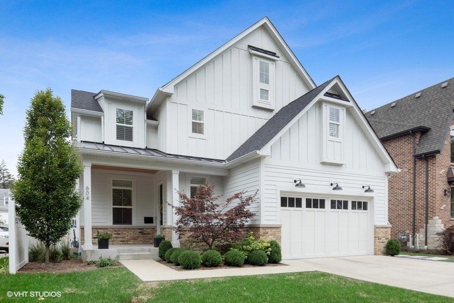 A large white house with a brick building in the background