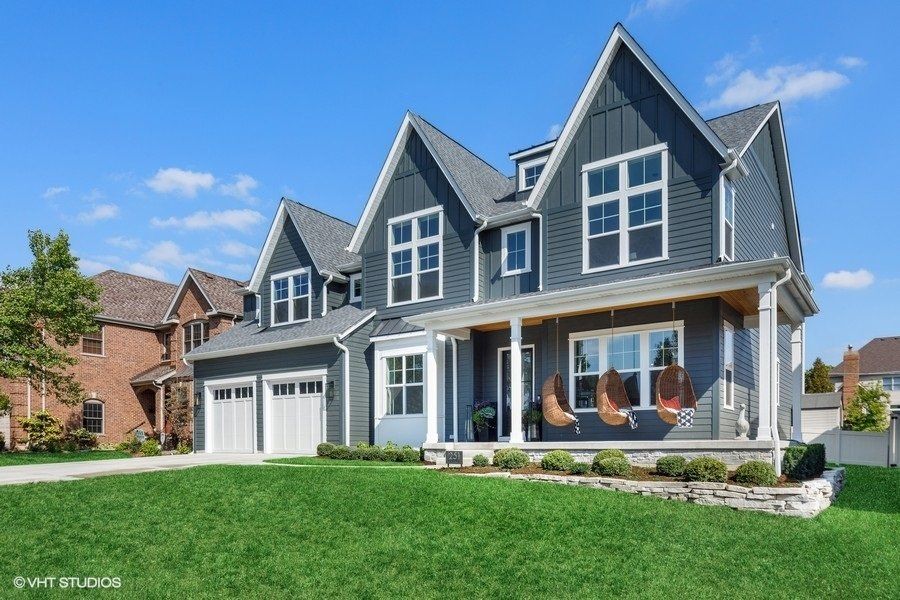 A large house with a lot of windows and a large lawn in front of it.