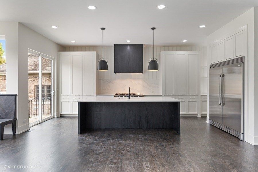 An empty kitchen with white cabinets and stainless steel appliances