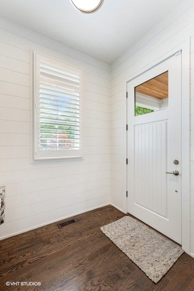 A white door with a window and a rug in front of it