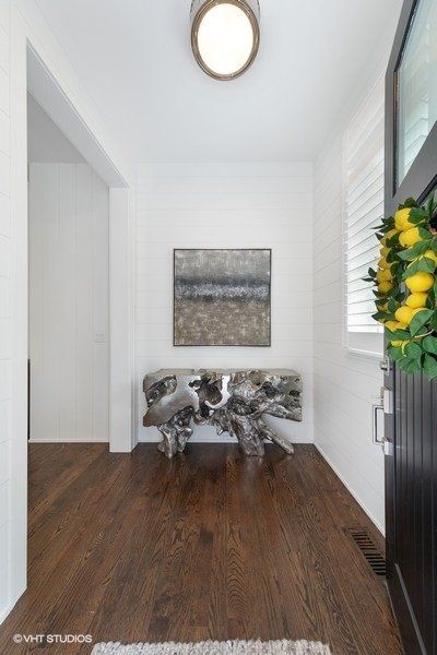 A hallway with a wooden table and a painting on the wall