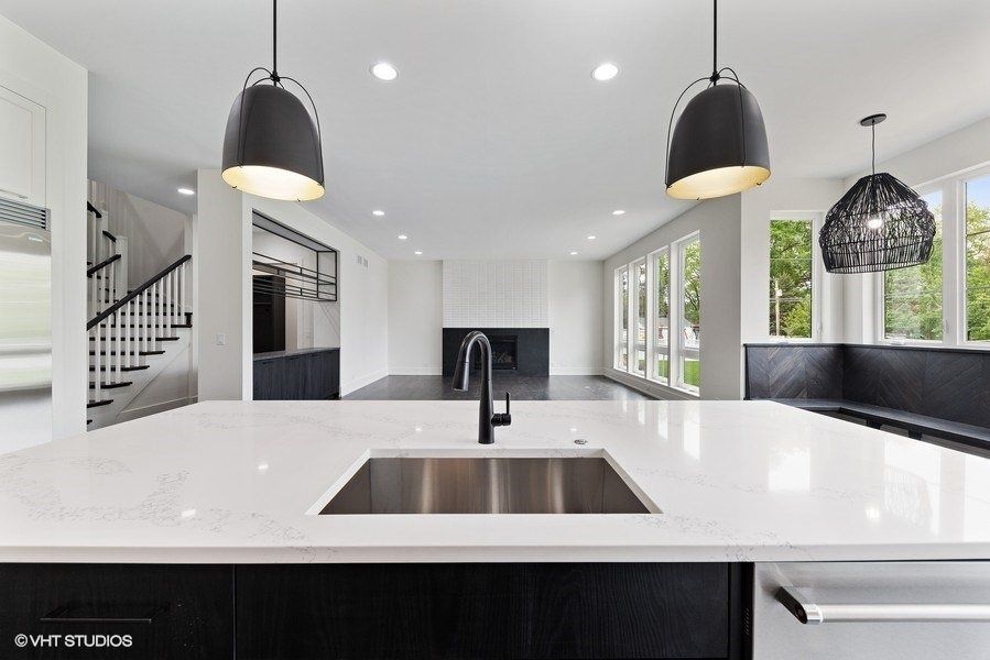 A kitchen with a sink and two pendant lights hanging from the ceiling.