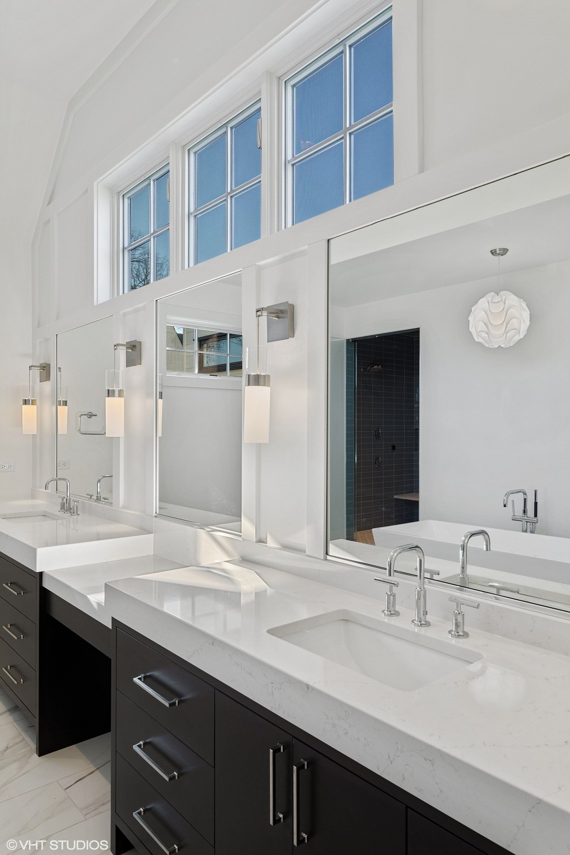 A bathroom with two sinks and two mirrors.