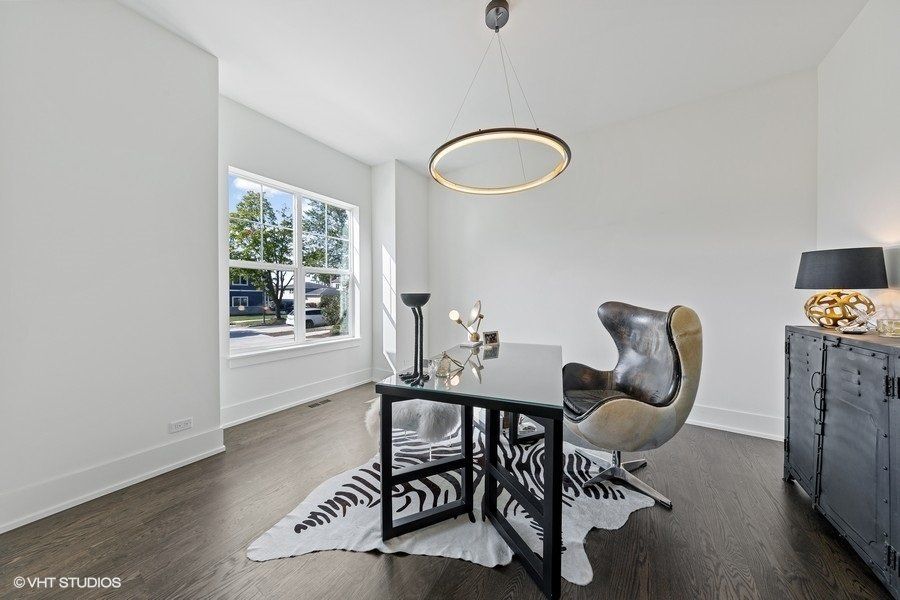 A home office with a desk , chair and rug.