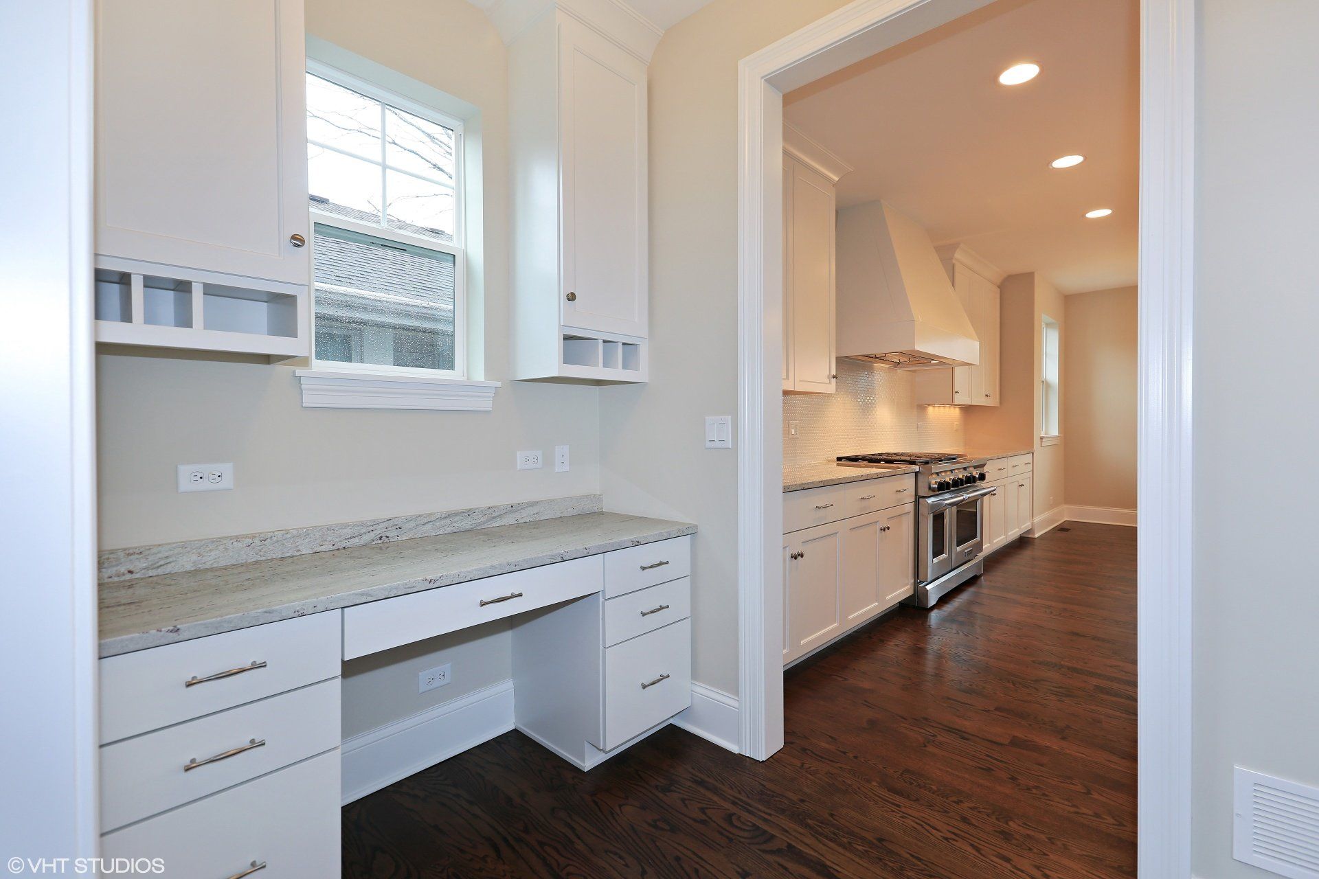 A kitchen with a desk in the middle of it