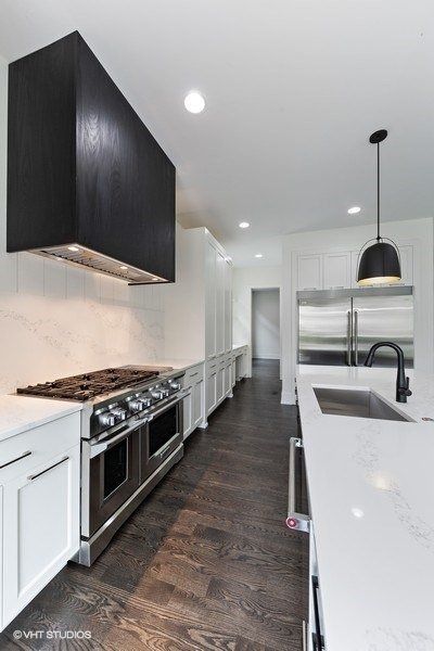 A kitchen with white cabinets and stainless steel appliances