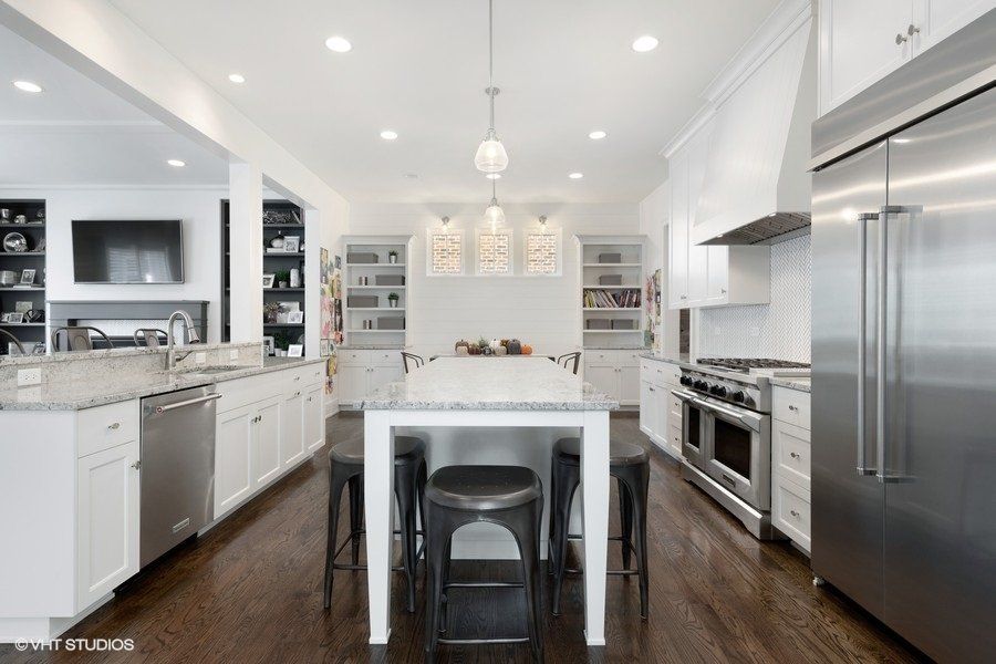 A kitchen with white cabinets and stainless steel appliances