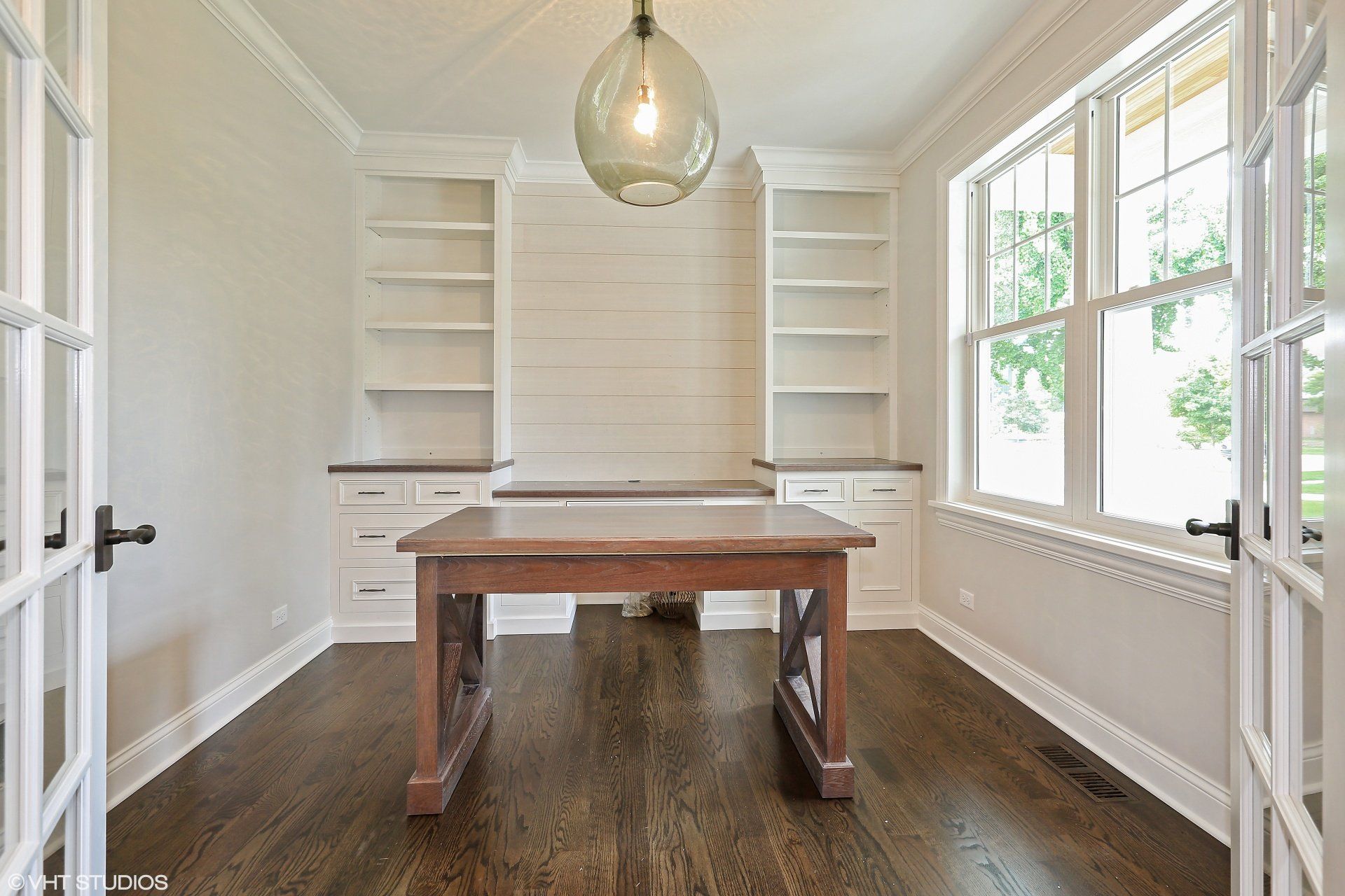 There is a wooden table in the middle of the room.