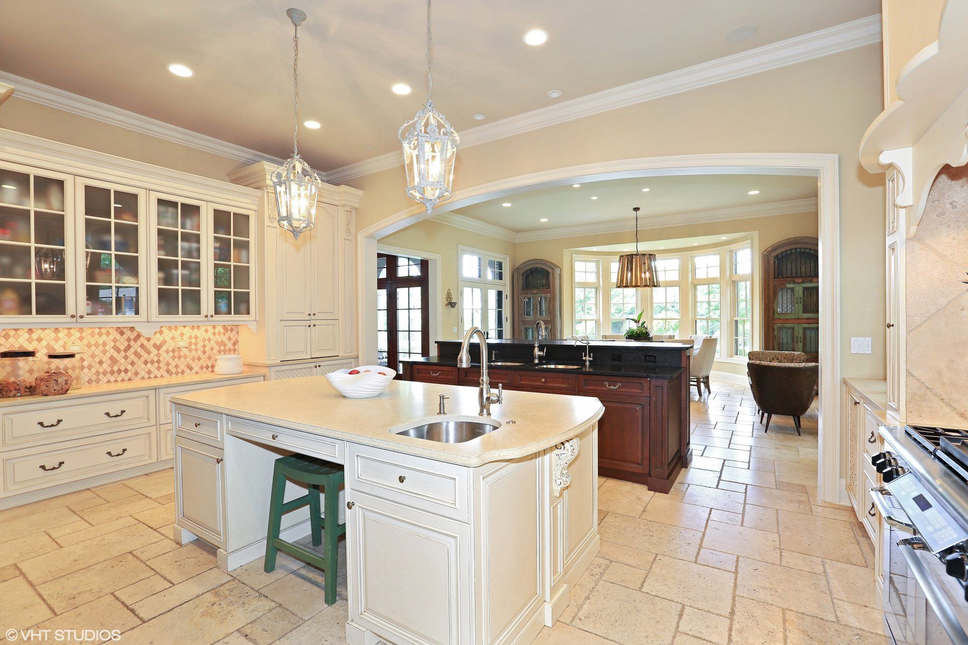 A large kitchen with a large island in the middle and stainless steel appliances.