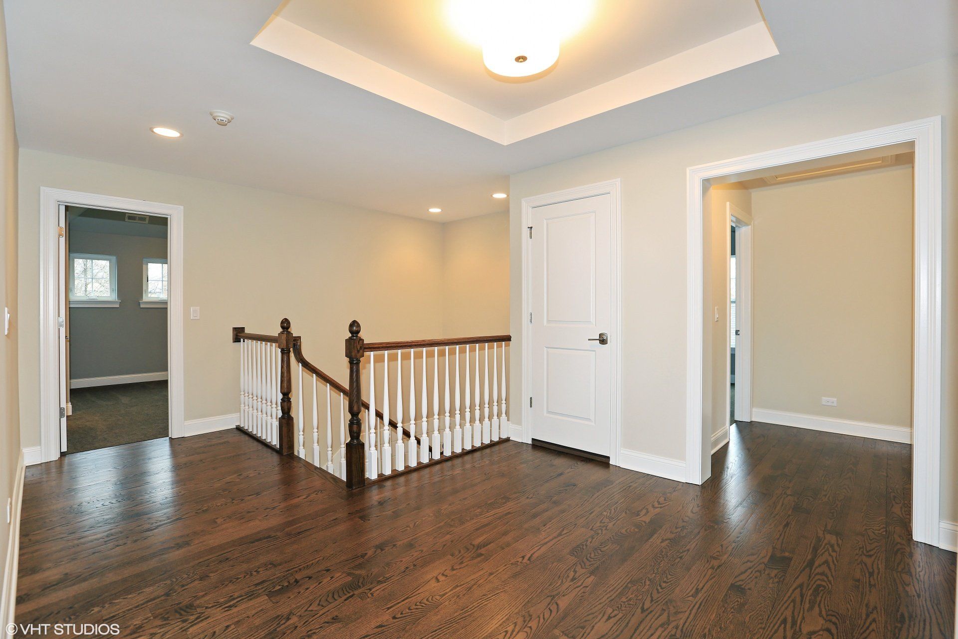 An empty room with hardwood floors and a staircase