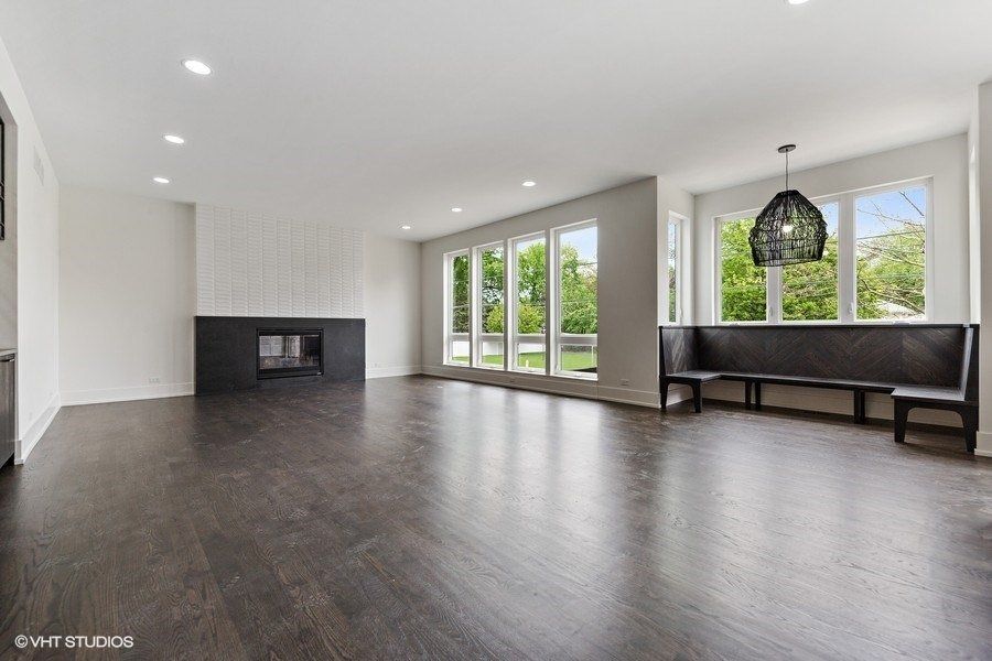An empty living room with hardwood floors and a fireplace.