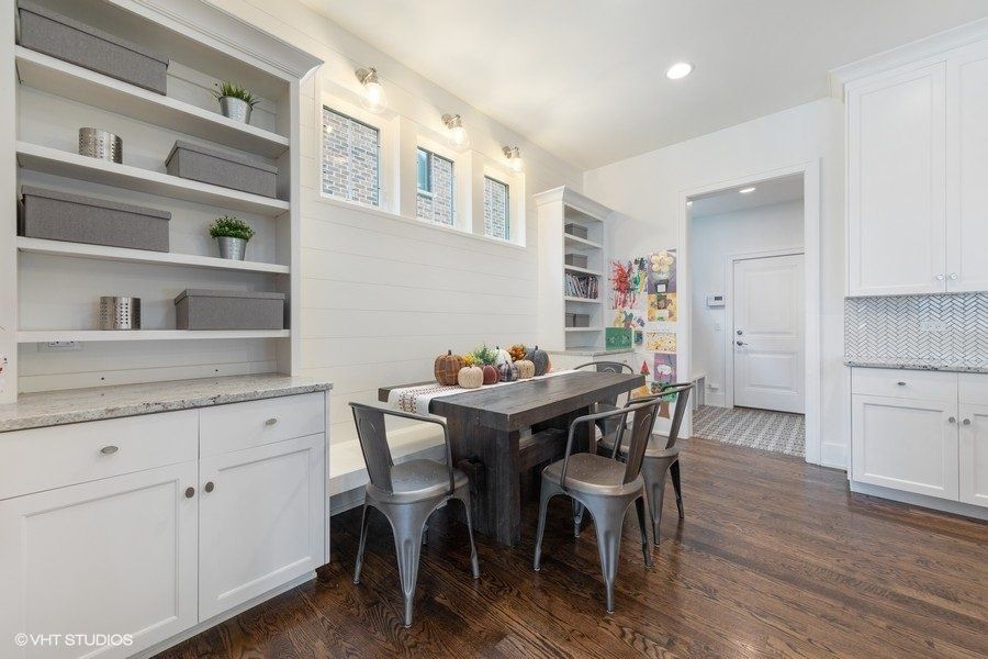 A dining room with a table and chairs and a bench.