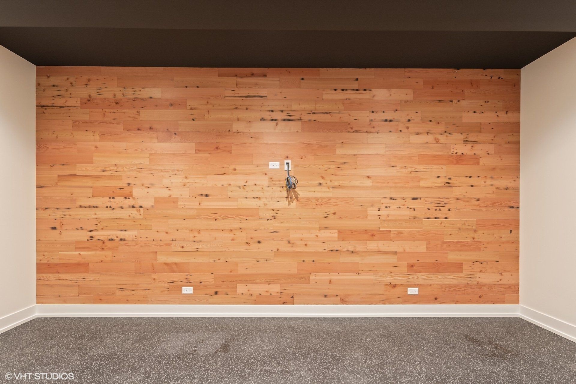 An empty room with a wooden wall and a black ceiling