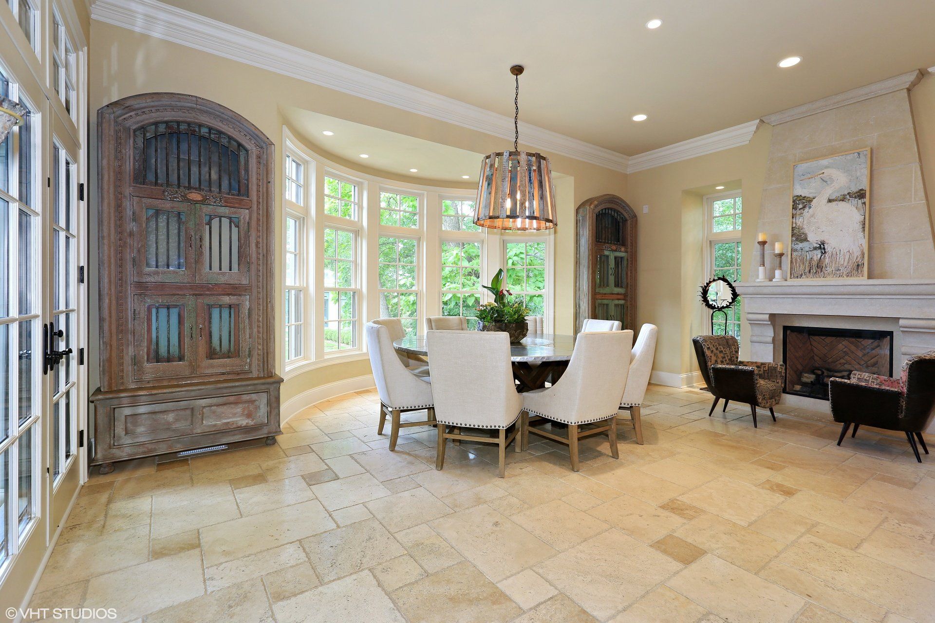 A dining room with a table and chairs and a fireplace.