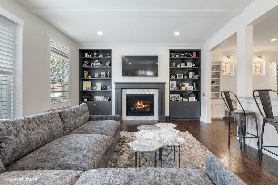 A living room with a couch , fireplace and television.