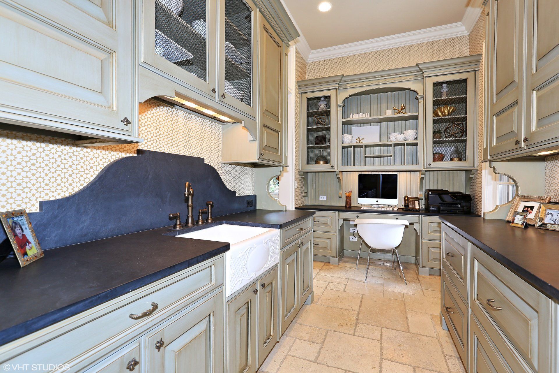 A kitchen with a sink and a computer desk