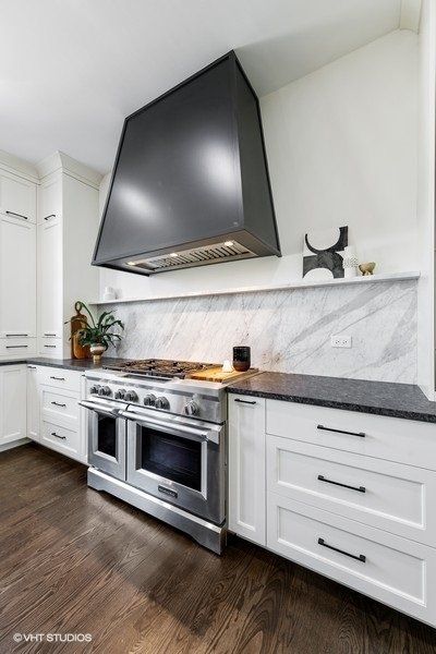 A kitchen with white cabinets and stainless steel appliances