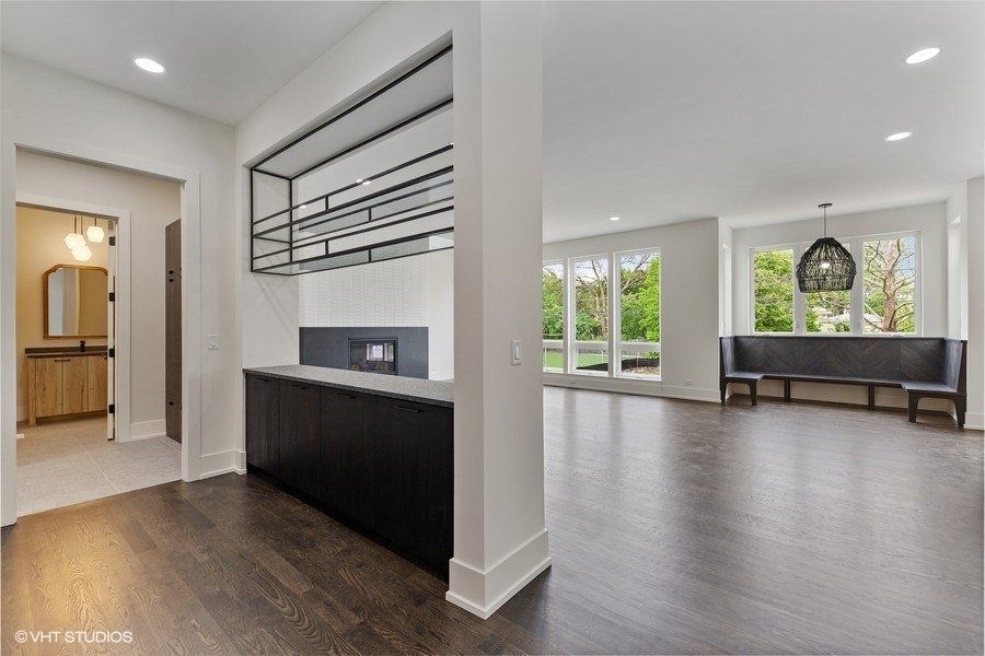 A large empty room with hardwood floors and white walls