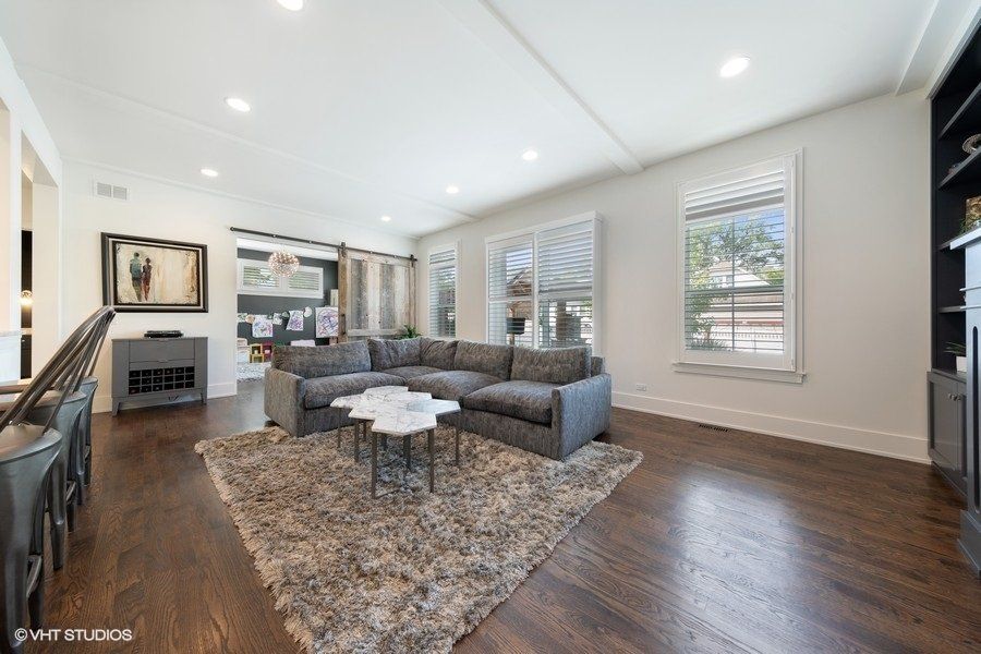 A living room with a large sectional couch and a rug.