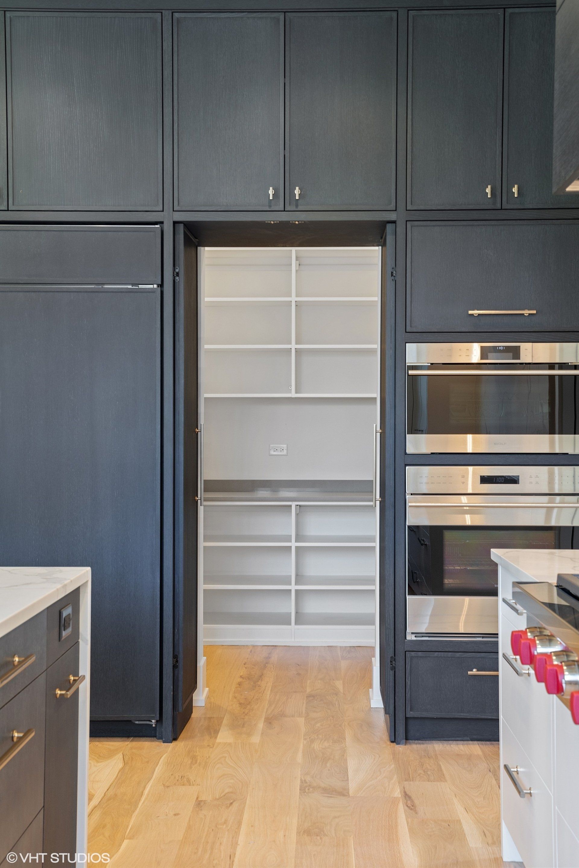 A kitchen with black cabinets and stainless steel appliances