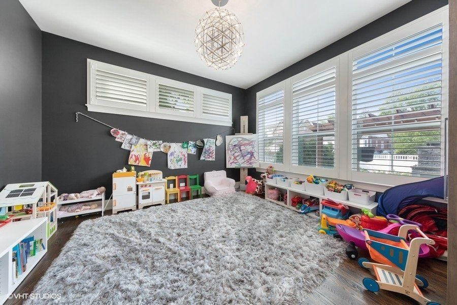A play room with lots of toys and a rug.