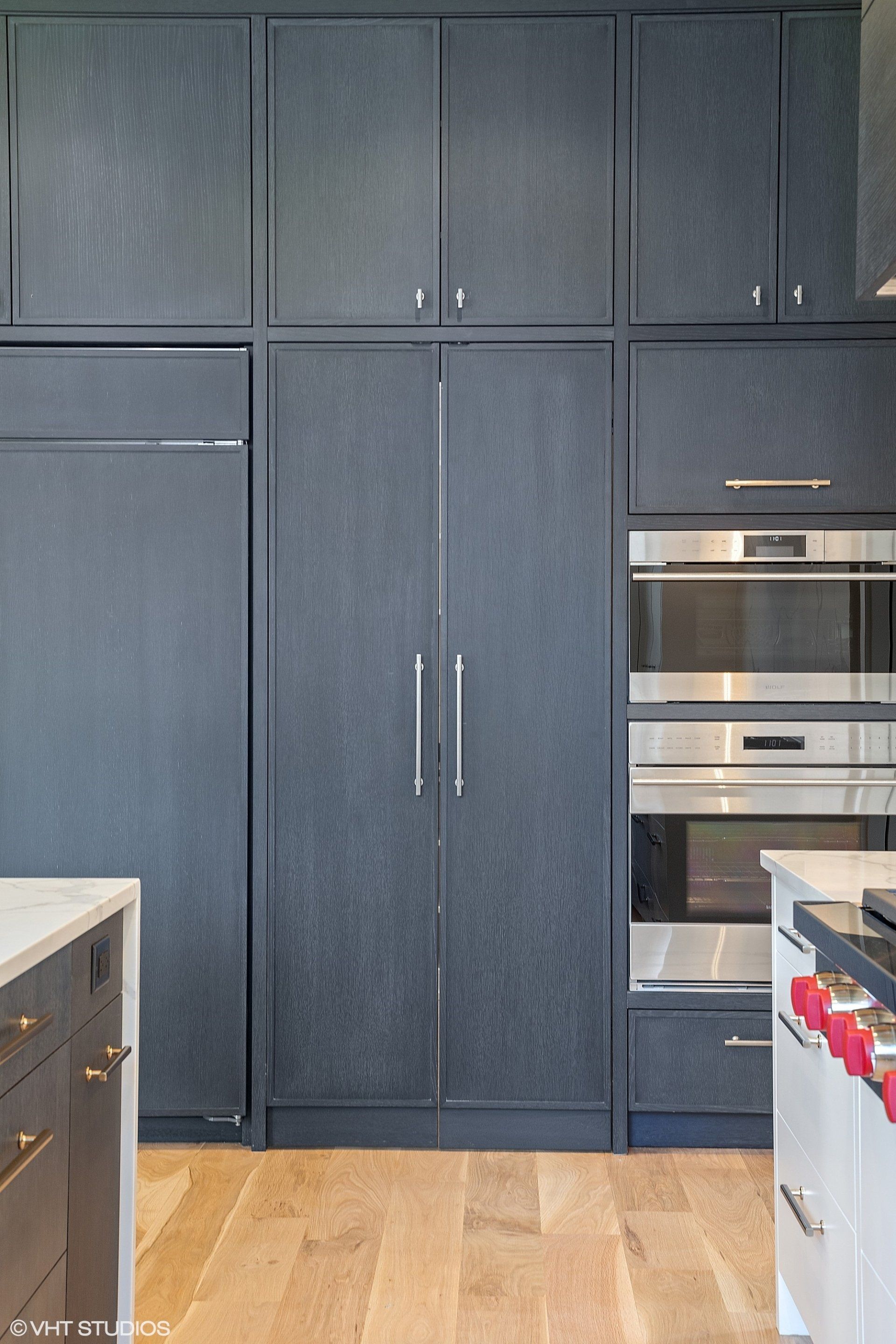 A kitchen with black cabinets and stainless steel appliances