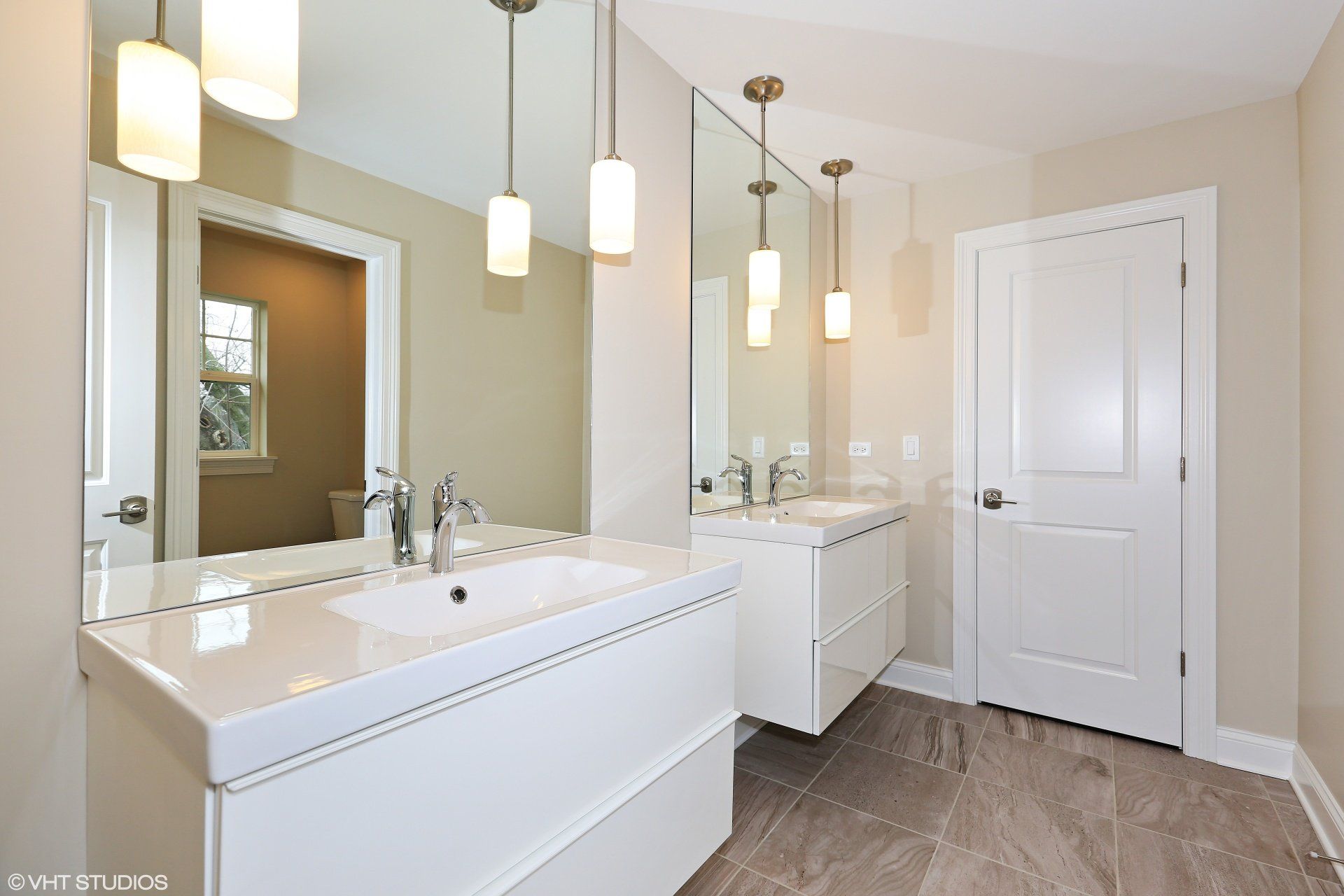 A bathroom with two sinks and a large mirror
