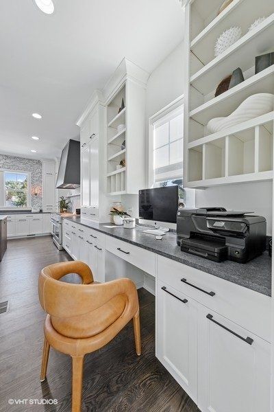A kitchen with a desk with a computer and printer on it