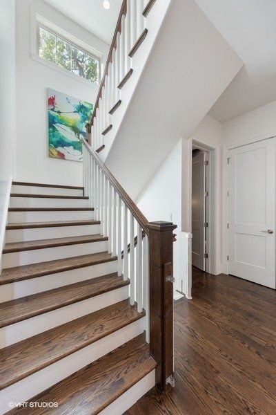 A staircase with wooden steps and a white railing
