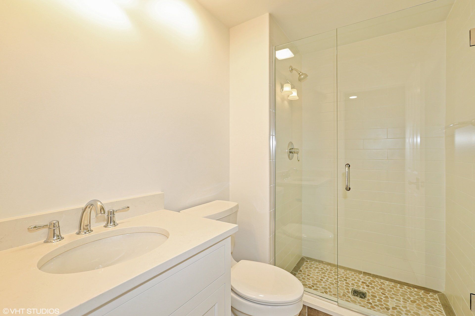 A bathroom with a toilet , sink and walk in shower.